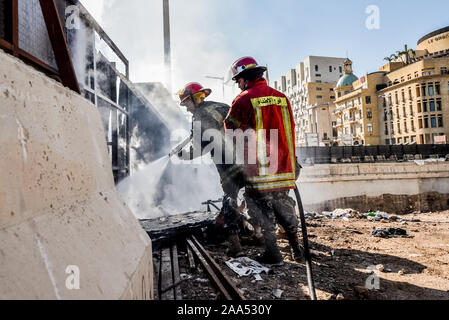 I pompieri spengono un incendio nel centro cittadino di Beirut oggi come manifestanti hanno evitato con successo i politici dal raggiungimento di una prevista sessione parlamentare. La sessione è stata rinviata a tempo indeterminato come le persone insistono che il governo di transizione si concentra sulla formazione di un frigocongelatore piuttosto che sul passaggio di nuova legislazione. 58 dei 128 membri del Parlamento anche boicottato la sessione. Foto Stock