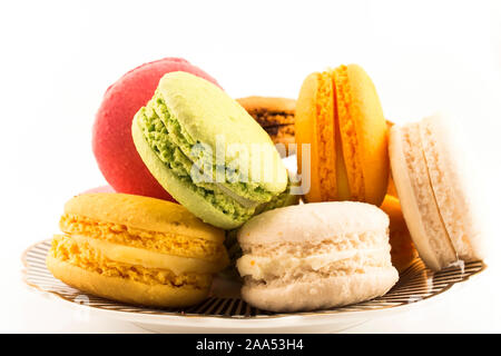 Un mucchio di amaretti colorati su una piastra isolata su sfondo bianco. Foto Stock