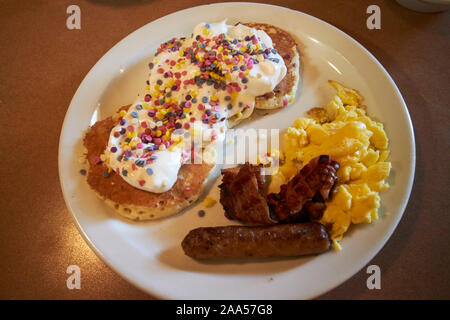 Junior torta di compleanno pancake, salsicce, uova e bacon per i pasti dei bambini a un dennys in Florida usa Foto Stock