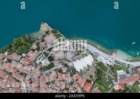 Antenna di overhead drone shot vista del villaggio litorale di Malcesine dal lago di garda Foto Stock