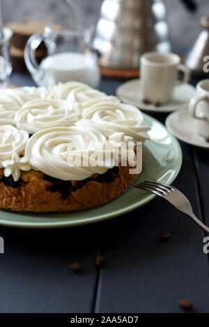 Close up di torte fatte in casa con crema di cocco volute servita con caffè su sfondo scuro copia spazio. Ancora in vita con illuminazione naturale con copyspace Foto Stock