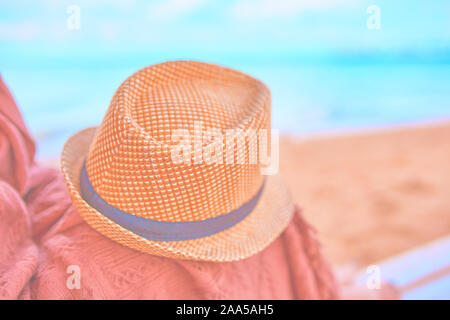 Cappello di paglia su una calda giornata sulla gamba womans con plaid Foto Stock