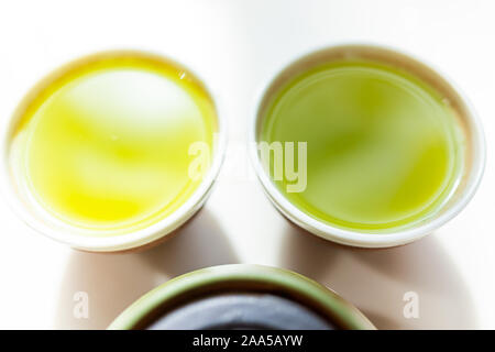 Primo piano della piccola due tazze riempite con il Giapponese vivace giallo verde sencha fukamushi o genmaicha tè colore per la prima colazione o la cerimonia Foto Stock