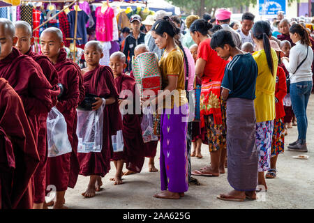 Il debuttante monaci a piedi giù per la strada principale di Pindaya Cerca Alms durante la grotta di Pindaya Festival, Pindaya, Stato Shan, Myanmar. Foto Stock