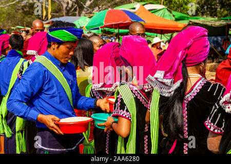 Un gruppo di giovani appartenenti a una minoranza etnica persone dando Alms/donazioni locali di monaci buddisti durante la grotta di Pindaya Festival, Pindaya, Stato Shan, Myanmar. Foto Stock