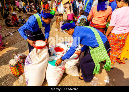 Un gruppo di giovani appartenenti a una minoranza etnica persone dando Alms/donazioni locali di monaci buddisti durante la grotta di Pindaya Festival, Pindaya, Stato Shan, Myanmar. Foto Stock