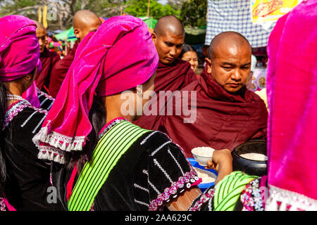 Un gruppo di giovani appartenenti a una minoranza etnica donne dando Alms/donazioni locali di monaci buddisti durante la grotta di Pindaya Festival, Pindaya, Stato Shan, Myanmar. Foto Stock