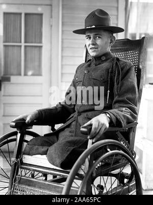 Soldato che ha perso le gambe nella I guerra mondiale nella sua sedia a rotelle ca. 1916-1919 Foto Stock