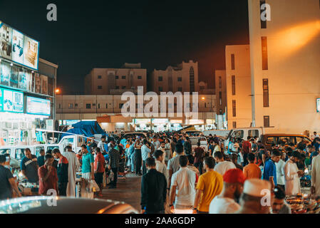La folla passeggiata attraverso il souq Al-Haraj, in cui i fornitori hustle abbigliamento e masserizie varie in bancarelle a Doha, in Qatar Foto Stock