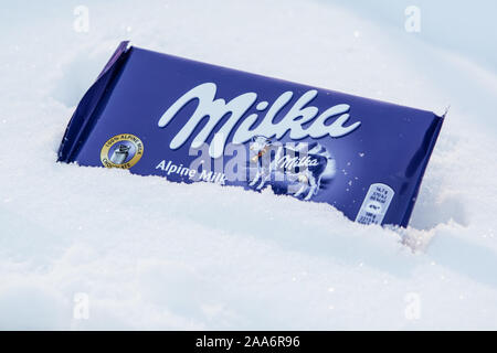 Un bar di Milka Mondelez Alpenmilch con cioccolato al latte di mucca viola, inverno, la neve Foto Stock