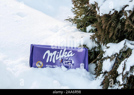 Un bar di Milka Mondelez Alpenmilch con cioccolato al latte di mucca viola, inverno, la neve Foto Stock