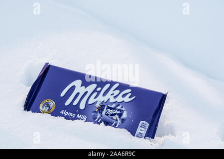 Un bar di Milka Mondelez Alpenmilch con cioccolato al latte di mucca viola, inverno, la neve Foto Stock