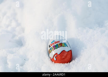 Kinder sorpresa uovo è costituito da un guscio di cioccolato, la capsula di plastica con il giocattolo e lamina esterna wrap. Sorpresa di parola scritta in lingua polacca. realizzato da Ferrero Foto Stock