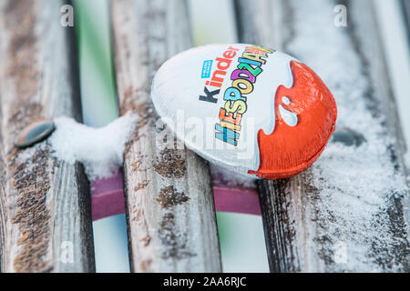 Kinder sorpresa uovo è costituito da un guscio di cioccolato, la capsula di plastica con il giocattolo e lamina esterna wrap. Sorpresa di parola scritta in lingua polacca. realizzato da Ferrero Foto Stock