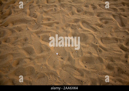 Spiaggia di sabbia con piedi stampe dei visitatori in Elliot's Beach, Chennai, India Foto Stock