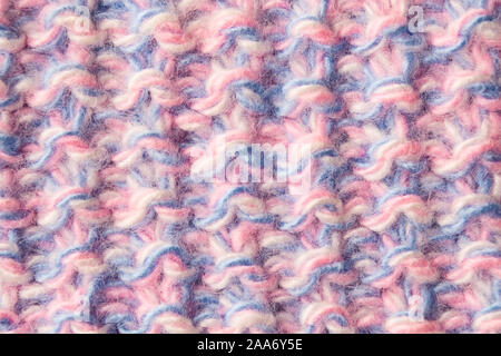 Vista ingrandita di tessili di lana a trama con sfondo blu e rosa thread. Caldo materiale morbido Foto Stock