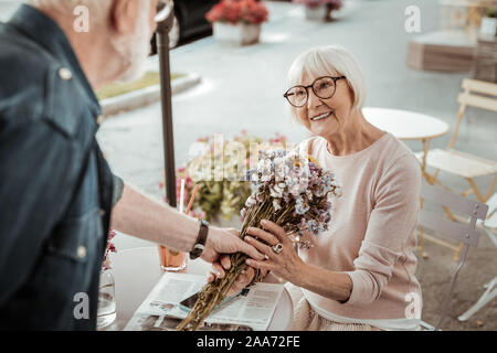 Felice bella donna di età compresa la ricezione di bellissimi fiori Foto Stock