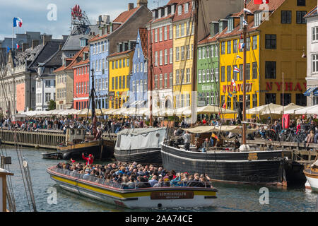 Nyhavn Copenhagen, vista in estate del popolare Nyhavn waterfront area con un gruppo di turisti in una gita in barca dei canali di Copenhagen, Danimarca. Foto Stock