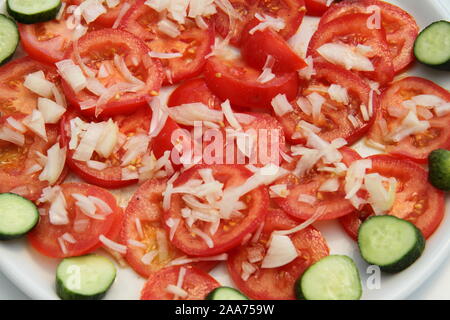 Pomodori, cetrioli e cipolle su una piastra Foto Stock