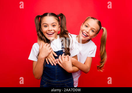 Foto di due divertenti piuttosto piccoli signori trascorrere weekend tempo insieme i tuoi amici godono di migliori vacanze indossare jeans globale di t-shirt bianco isolato di colore rosso Foto Stock