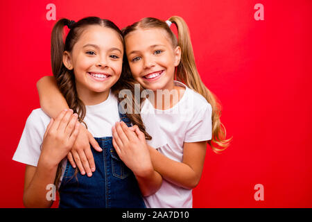 Foto di due divertenti piuttosto piccoli signori abbracciando trascorrere weekend tempo insieme godono di migliori vacanze indossare jeans globale di t-shirt bianco isolato di colore rosso Foto Stock