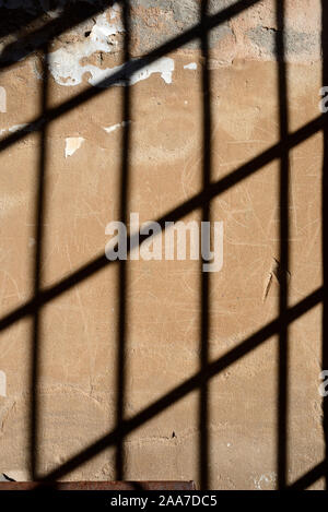 Modello di ombra sul vecchio Muro di barre metalliche o Iron-Barred Windows in prigione o cella di prigione Foto Stock