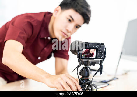 Giovani asiatici blogger maschio di impostazione della telecamera per la registrazione live di vlog video tutorial session a casa. Esso blogging o vlogging, social media broadca hobby Foto Stock