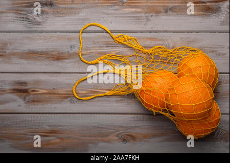 Arance in una stringa di maglia borsa fatta di materiale naturale. Protezione ambientale Foto Stock