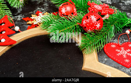 Natale o Capodanno in legno scuro, sfondo nero Xmas bordo incorniciato con decorazioni di stagione, spazio per un testo, vista da sopra Foto Stock