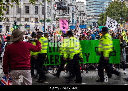 London, England, Regno Unito - 10 Ottobre 2019: un turista scatta una fotografia di una ribellione di estinzione protesta in Trafalgar Square a Londra centrale. Foto Stock