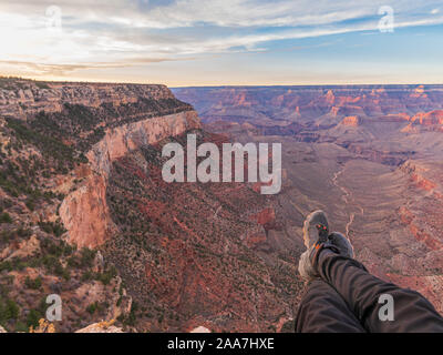 Foto di gambe in scarpe da trekking sullo sfondo del Grand Canyon Foto Stock