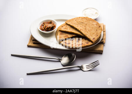 Sattu Ka Paratha / Stuffed Chana dal Flour Paratha servito con sottaceti di mango e cagliata o dahi Foto Stock