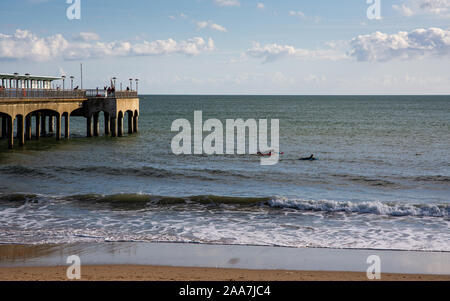 Bournemouth, Inghilterra, Regno Unito - 6 Ottobre 2019: persone nuotare nel canale inglese accanto a Boscombe Pier sulla spiaggia di Bournemouth nel Dorset. Foto Stock