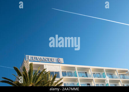 Cala Bona, Maiorca, Spagna, 19 ottobre 2019, Hotel Levante con un aeromobile sentiero in un cielo blu chiaro. Foto Stock