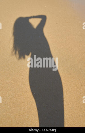 Ombra dal fotografo ragazza nella sabbia, silhouette nella sabbia, wave Foto Stock