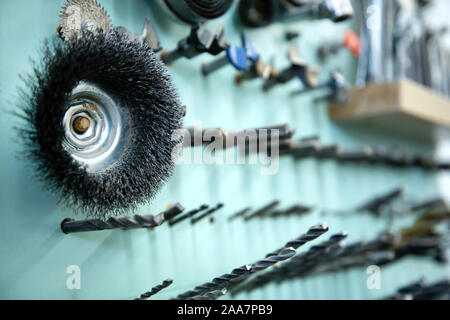 Perfettamente organizzata selezione di utensili per la lavorazione del legno su una parete in un laboratorio di falegnameria in una vista ravvicinata sulle punte da trapano Foto Stock