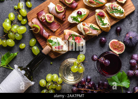 A buffet con vino snack set. Le tapas tradizionali - tabella di spagnolo con il cibo o antipasto italiano: bruschetta con il formaggio e la carne. Foto Stock
