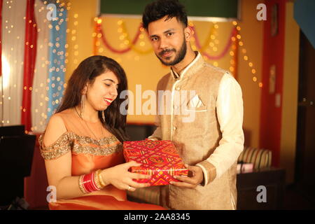 Indian giovane celebra Diwali. Isolato su sfondo decorativo. Foto Stock