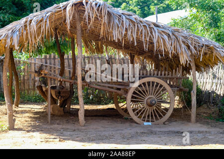 Tradizionale birmana ox carrello realizzato in legno e protetti dalle intemperie sotto una coperta di paglia sparso in un villaggio al di fuori di Bagan, Myanmar (Birmania) Foto Stock