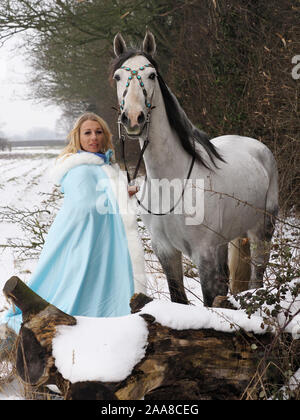 Una magica cercando girl e cavallo in un paesaggio innevato. Foto Stock