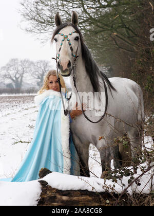 Una magica cercando girl e cavallo in un paesaggio innevato. Foto Stock