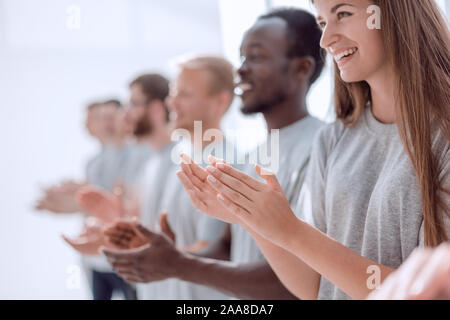 Immagine di un gruppo di giovani in piedi in una fila ad applaudire. Foto Stock