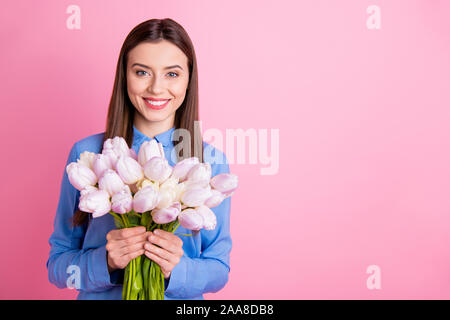 Foto di sorprendente lady azienda grande bianco fresco tulipani mazzetto in mani migliori 8 marzo sempre indossare puntini blu shirt rosa isolato colore di sfondo Foto Stock