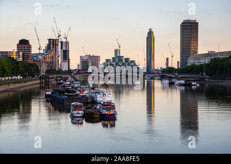 London, England, Regno Unito - 3 Luglio 2016: Tramonto su Lambeth Bridge e traghetti ormeggiati nel fiume Tamigi, con lo skyline di Vauxhall e Nine Elms Foto Stock