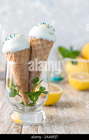 In casa di marshmallow di limone in un cono di cialda per il gelato alla crema di cioccolato bianco glassa. Dolci fatti in casa. Marshmallows in forma di gelato. Foto Stock