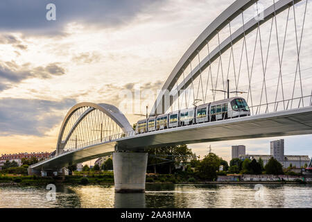 Un piattaforme Citadis tram di Strasburgo tramvia sta attraversando il Beatus Rhenanus ponte per servire Kehl sul lato opposto del Reno da una burrascosa serata. Foto Stock