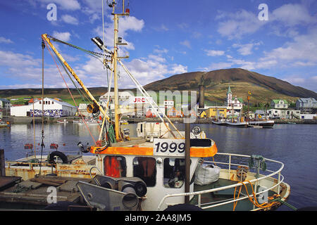 Pescherecci nel porto con la città dietro, Husavik, n.e. L'Islanda. Foto Stock