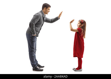 Lunghezza piena ripresa di profilo di un padre e figlia facendo una alta cinque gesto isolato su sfondo bianco Foto Stock