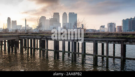 London, England, Regno Unito - 17 Febbraio 2013: Ufficio grattacieli di Canary Wharf financial district salire dietro un abbandonato ed incolto p industriali Foto Stock