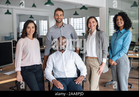 Team diversificato di sorridere imprenditori lavora in un ufficio moderno Foto Stock